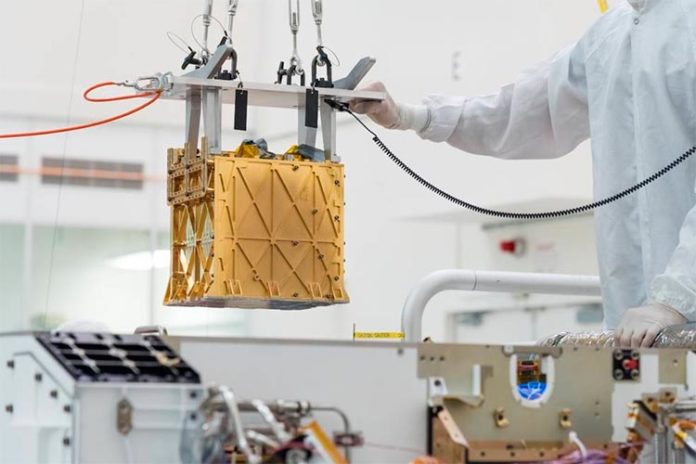 Técnicos del Laboratorio de Propulsión a Chorro de la NASA bajan el instrumento del Experimento de Utilización de Recursos In-Situ de Oxígeno de Marte (MOXIE) al vientre del rover Perseverance Técnicos del Laboratorio de Propulsión a Chorro de la NASA bajan el instrumento del Experimento de Utilización de Recursos In-Situ de Oxígeno de Marte (MOXIE) al vientre del rover Perseverance