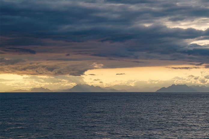 Nubes cargadas y la costa sur de Alaska enmarcan el Golfo de Alaska durante un crucero científico en el verano de 2017