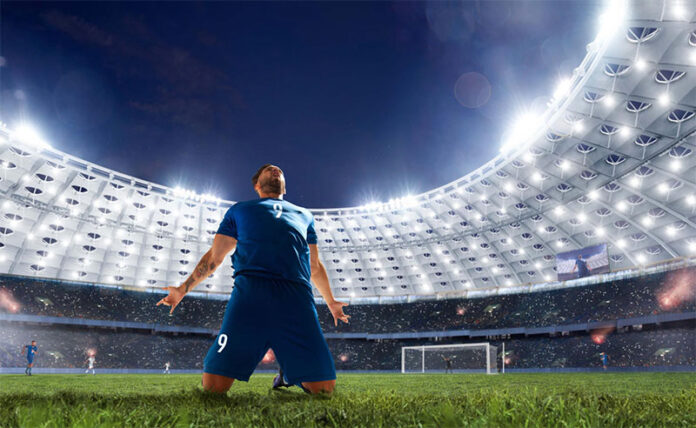 Jugador de fútbol en estadio celebra un gol