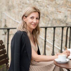 La autora Eva García Sáenz de Urturi mira a cámara mientras sostiene un bolígrafo y una libreta. 